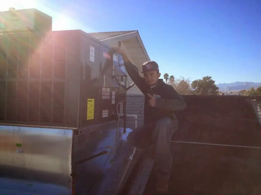 HVAC technician performing Heat Pump Repair on a rooftop unit in Bemiss